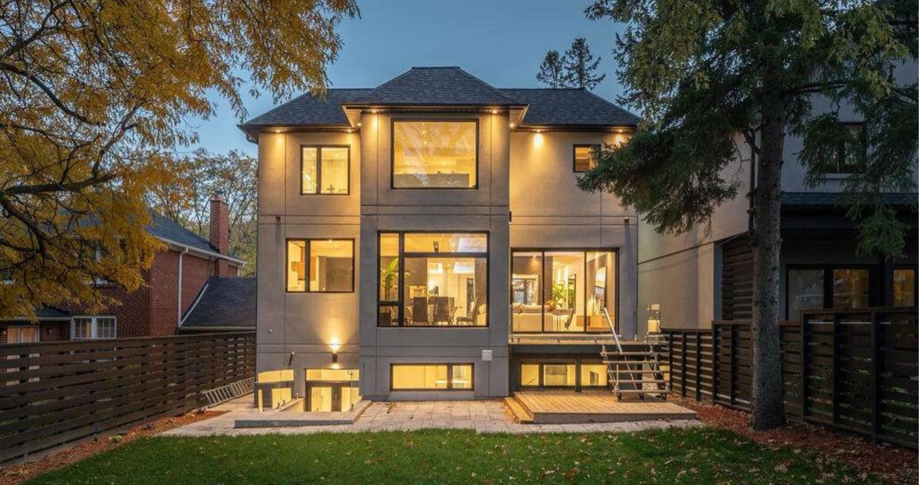 Rear elevation of a custom home by Atena at dusk